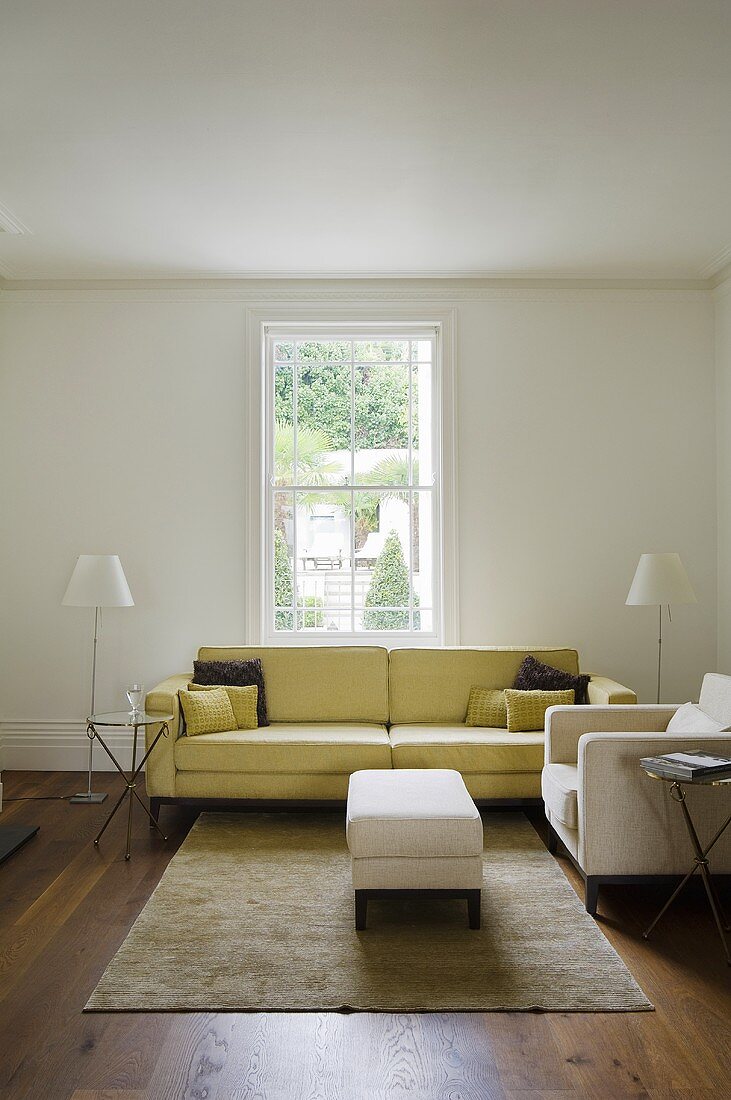 A yellow upholstered sofa in a minimalistic living room with a view