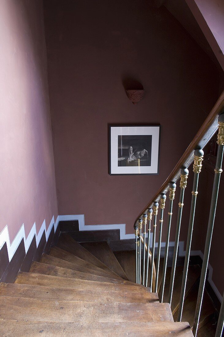 A steep flight of wooden stairs and a dark red wall