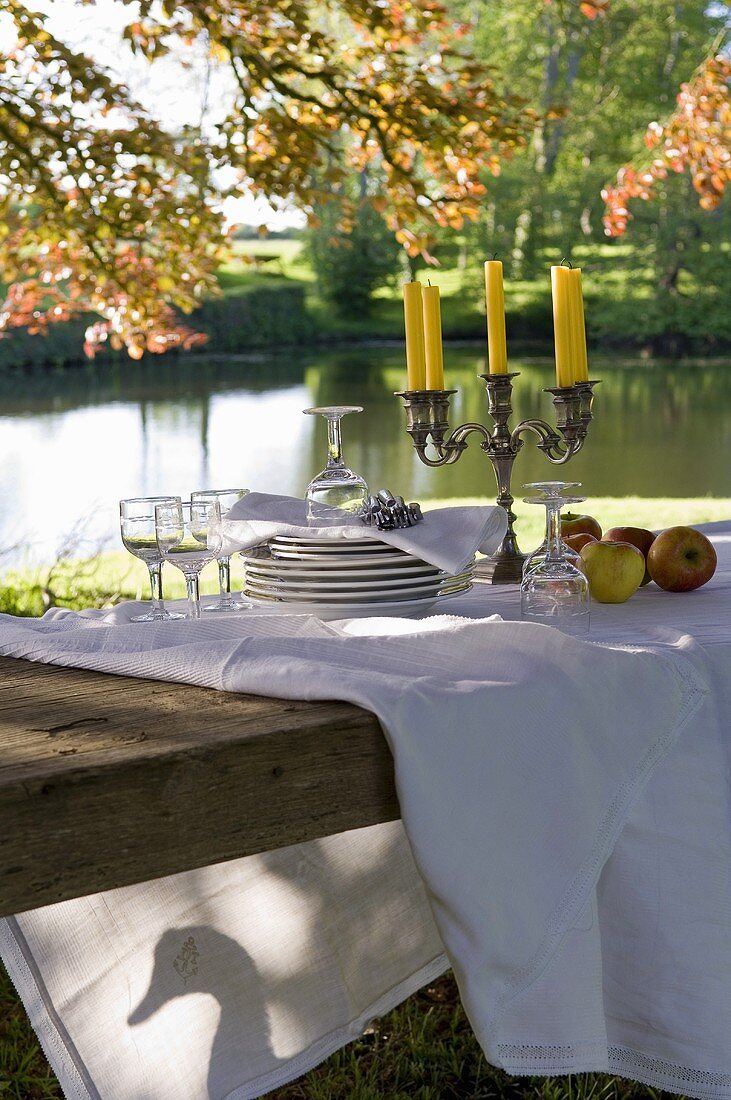 Festliches Herbstpicknick unter Bäumen mit Blick auf einen Weiher