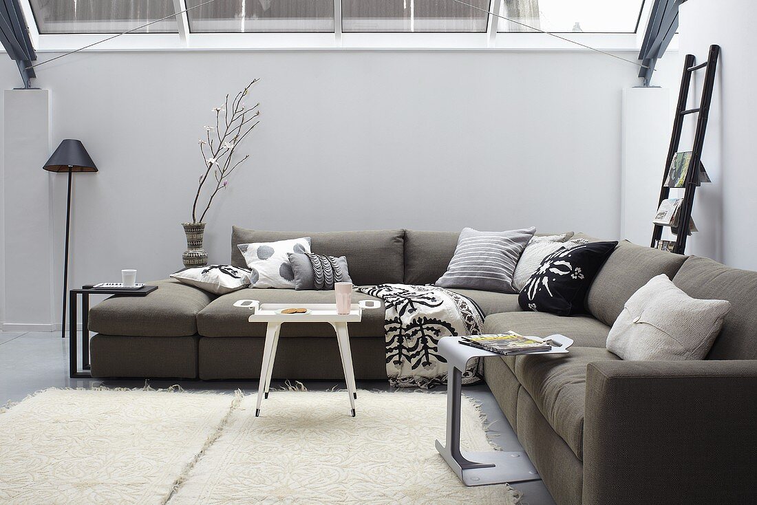 Relaxation in the conservatory - a grey corner sofa and a white flokati rug