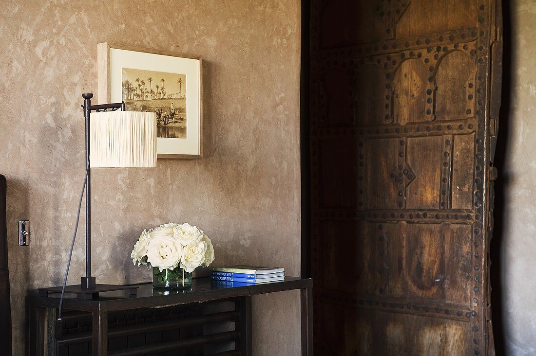 Tischlampe auf Beistelltisch und Blick auf geöffneter Zimmertür in rustikalem Stil