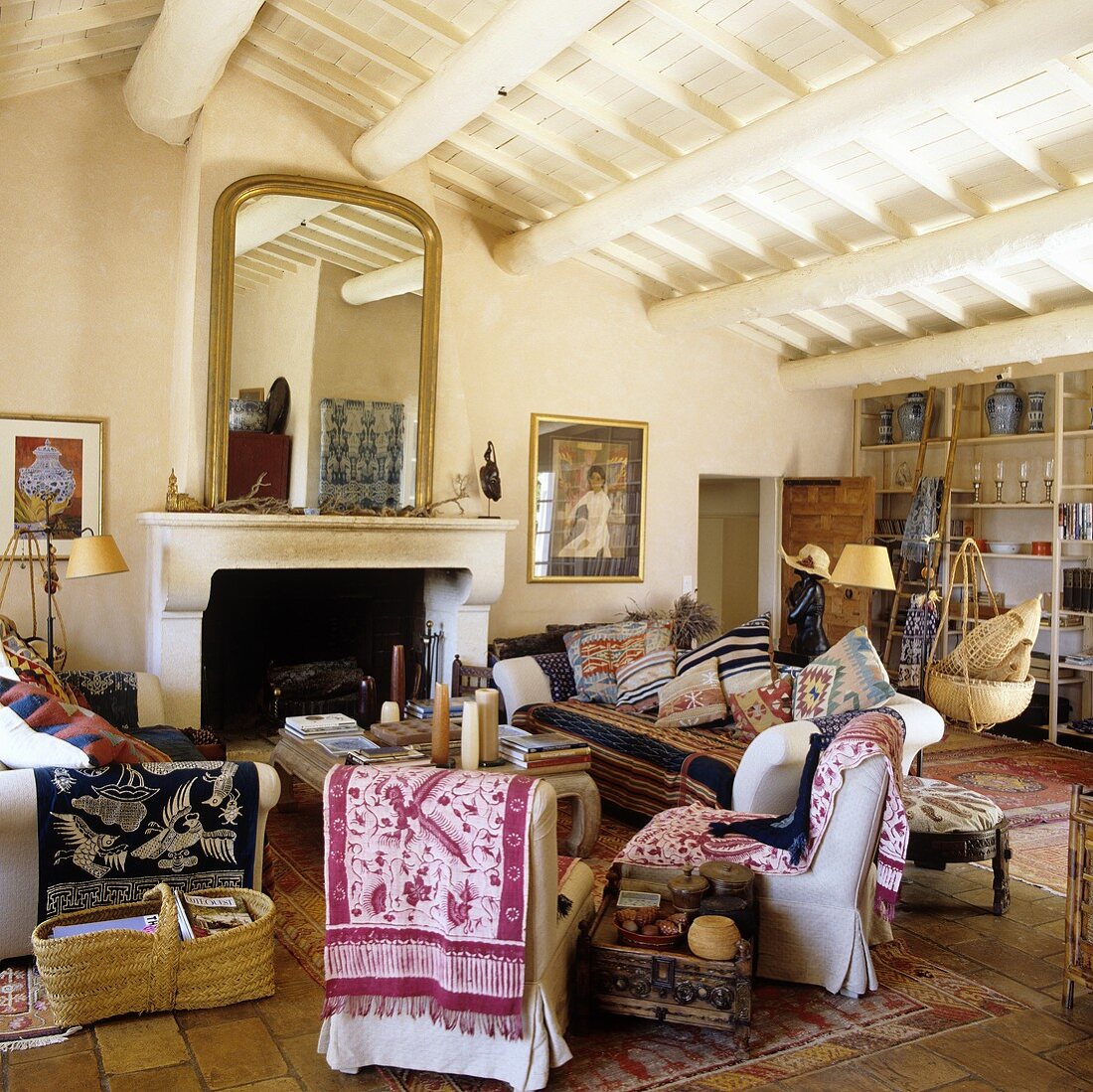 Ethnic throws on a sofa in a Mediterranean living room with a rustic wood beam ceiling
