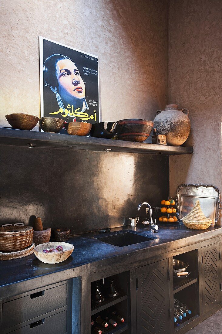 Mediterraner Küchenecke - Ablage mit Schalen und Arbeitsplatte mit dunkelgrauen Einbauschränken