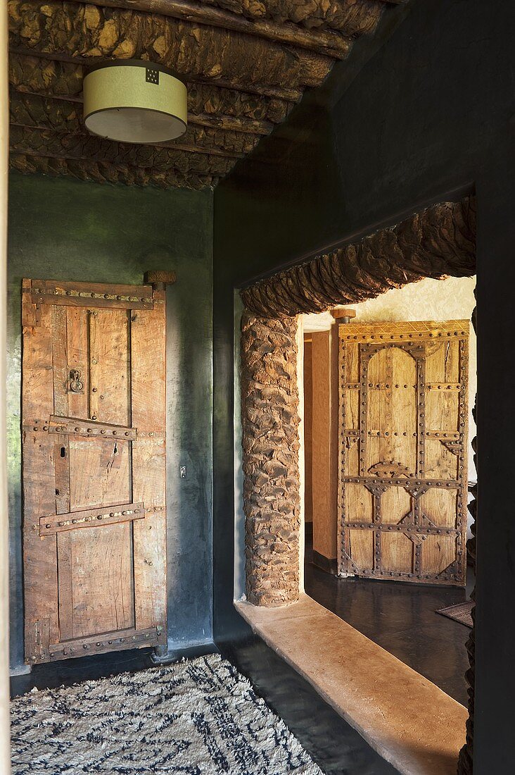 An anteroom with rustic doors and a view into the next door room of a Mediterranean country house