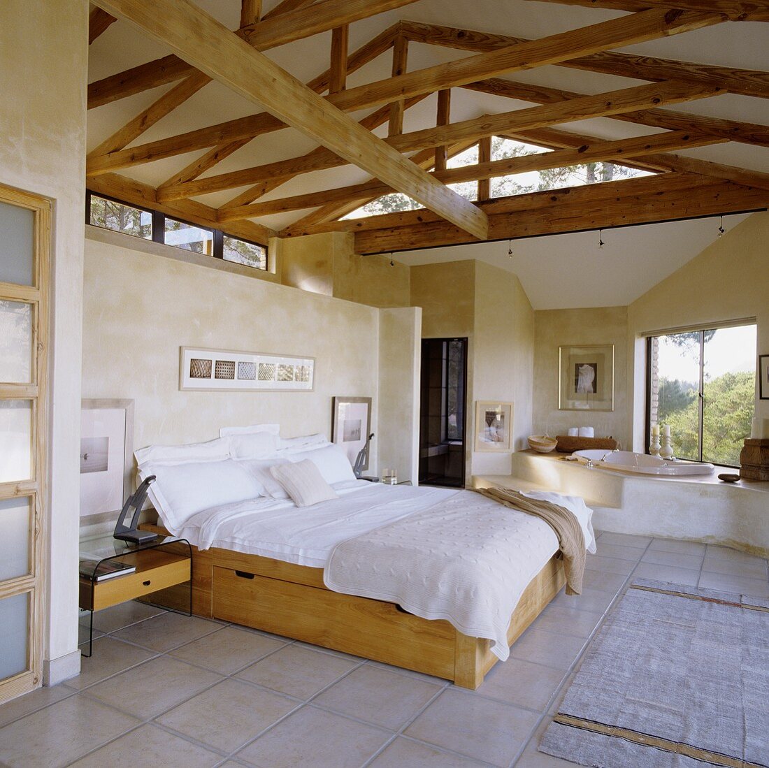 An open-pan bedroom-cum-bathroom in a converted attic with wood beams
