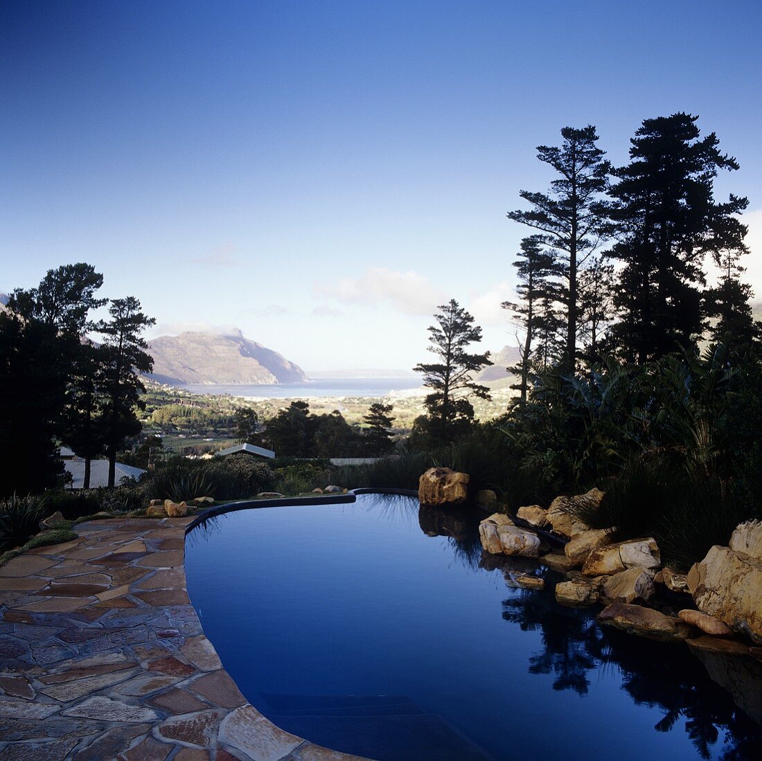 Blick über stahlblauen Pool auf beeindruckende Landschaft in Südafrika