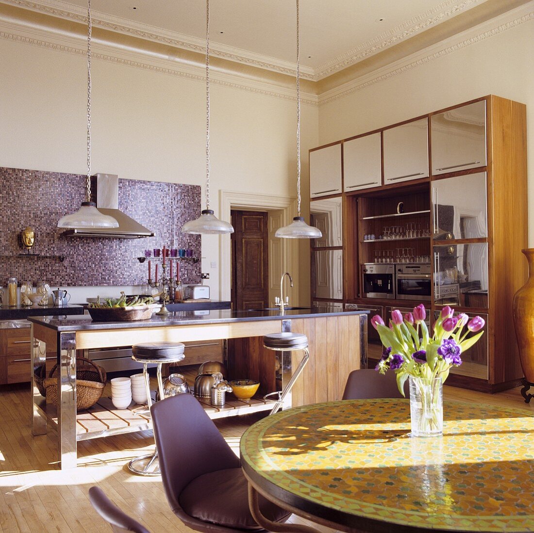 An open-plan kitchen in a villa with a dining area in front of the counter