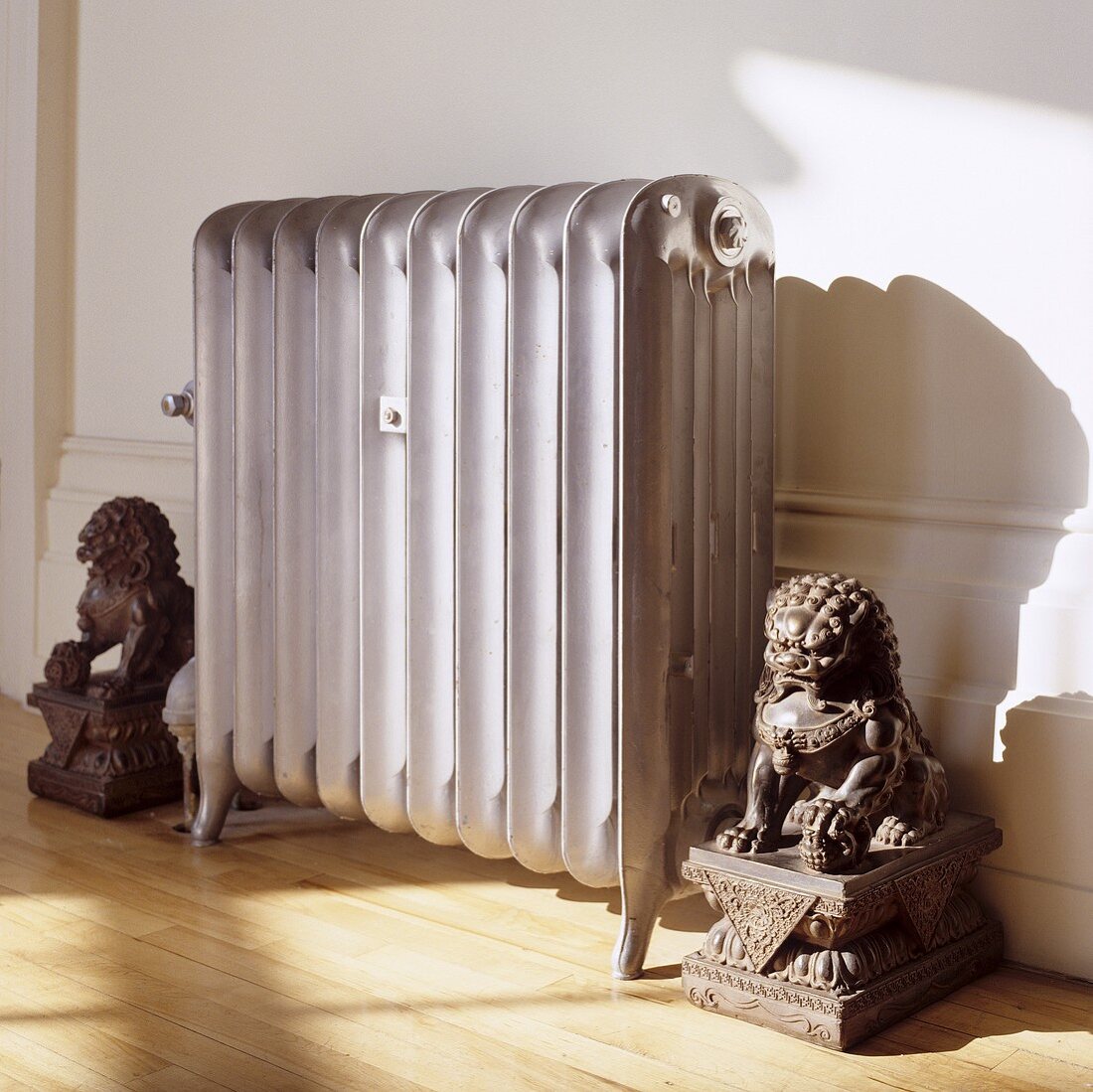 An old grey radiator guarded by lion figures