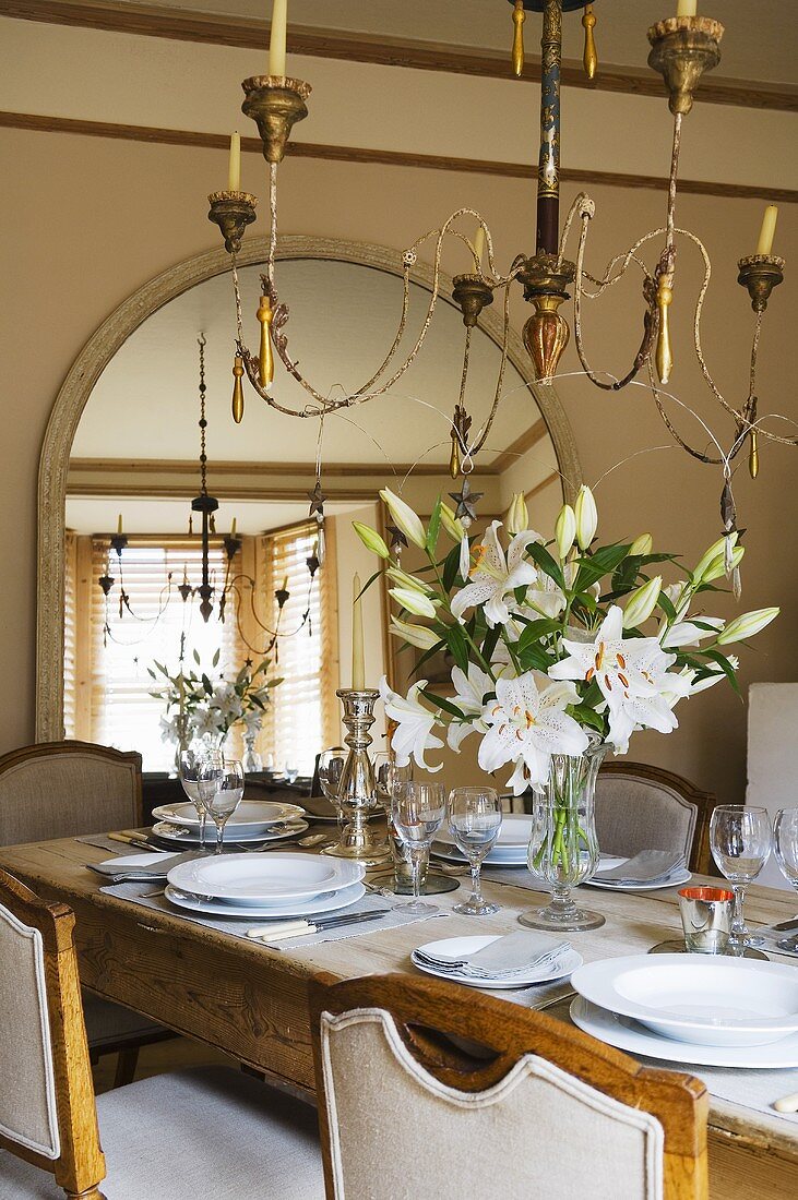 A table laid with a bunch of white lilies under a chandelier