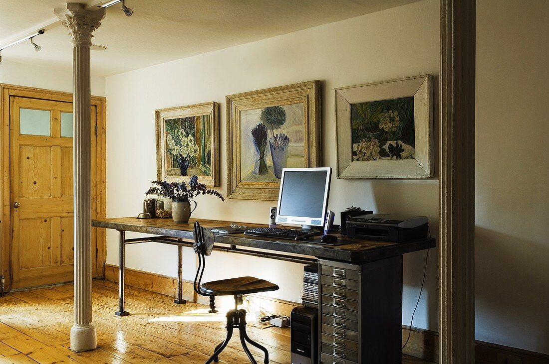 A modern desk between two metal pillars in a room in country house