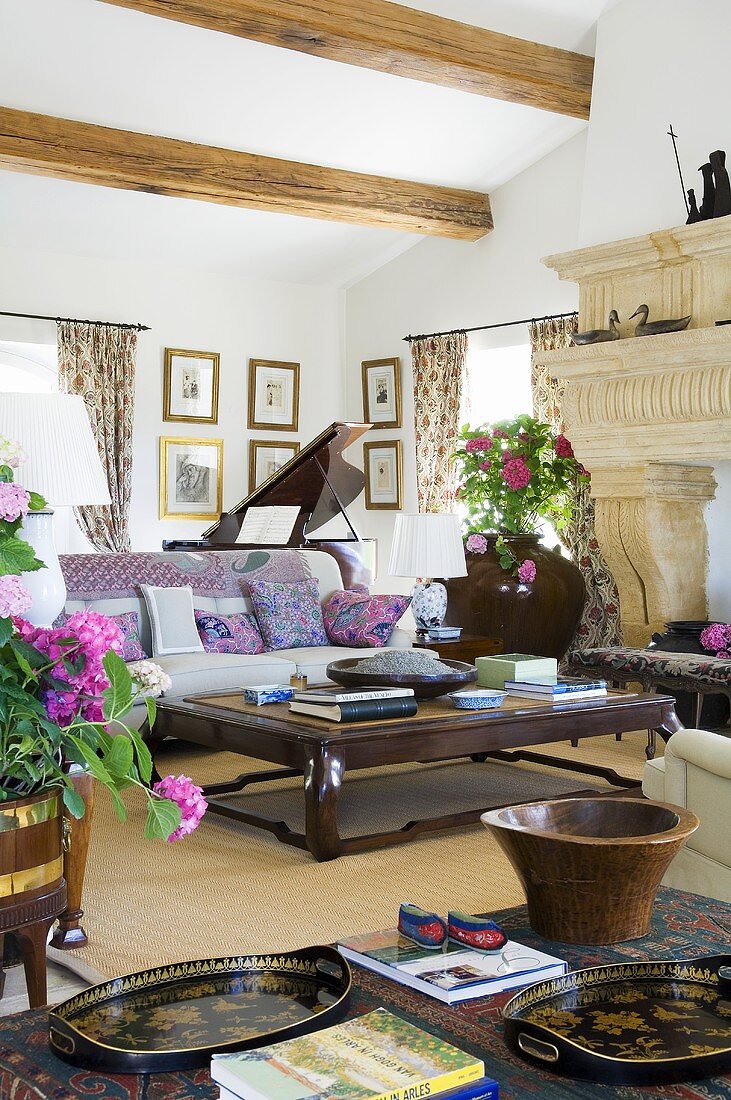 A coffee table and a sofa in a Mediterranean living room with a wood beam ceiling