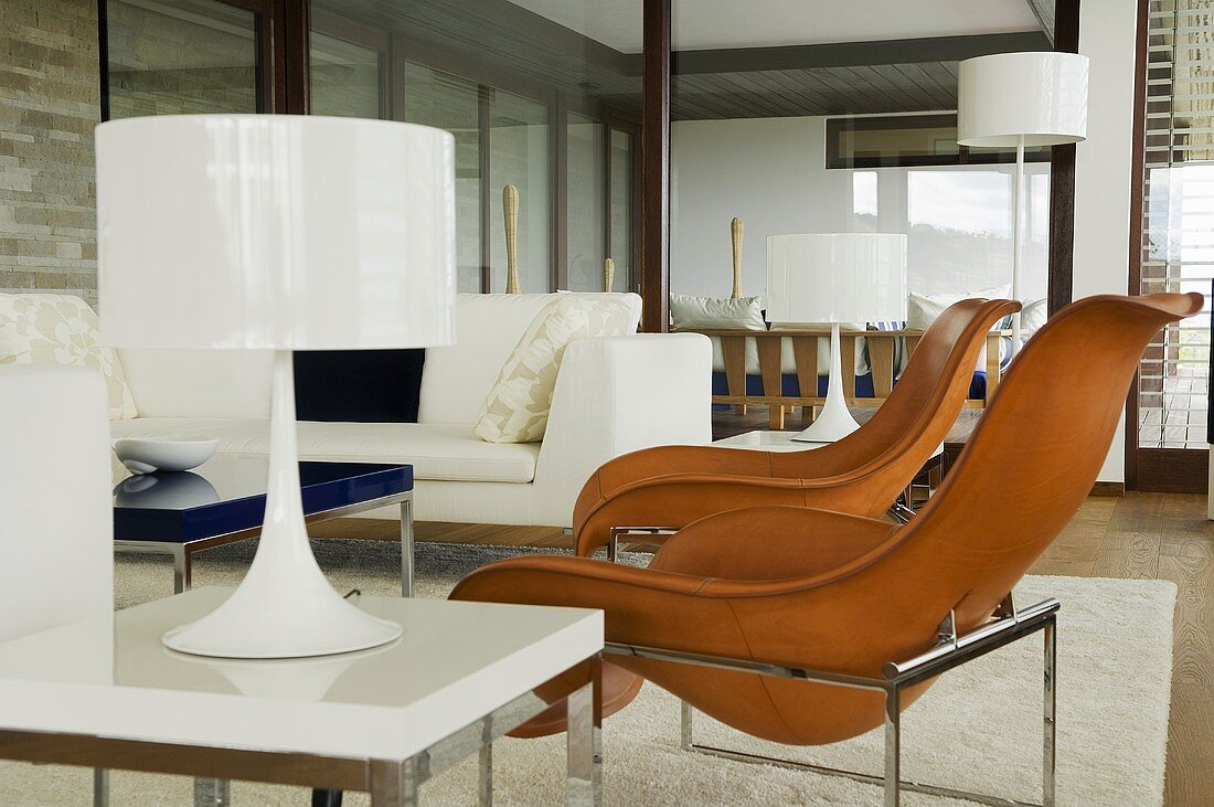 Brown leather bucket chairs and white table lamps in a living room