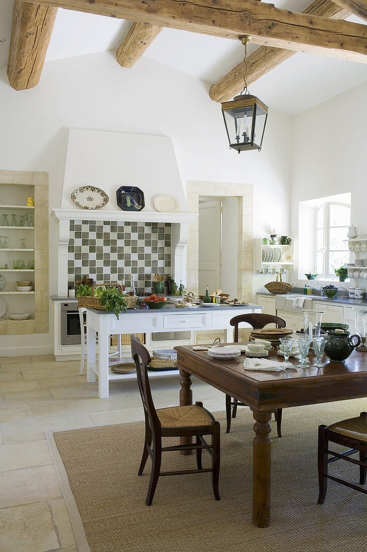 Esstisch und Küchentisch in rustikaler Landhausküche mit Holzbalkendecke