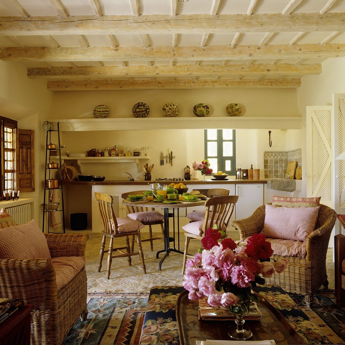 A living room-cum-kitchen with wicker chairs in a simple Mediterranean country house
