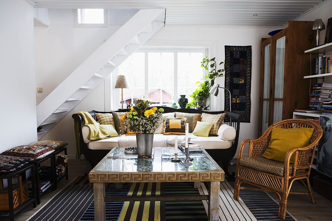 Maisonette apartment living - a coffee table and a wicker chair with a flight of stairs in the background
