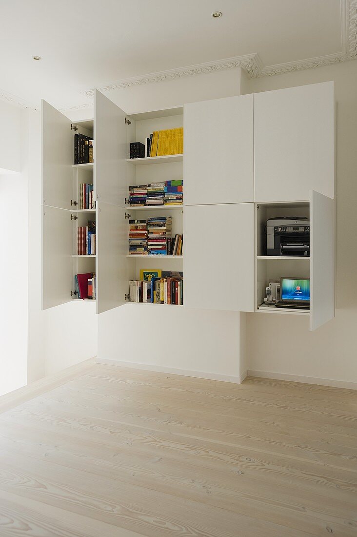 White, tailor-made cupboard with open doors in a period building