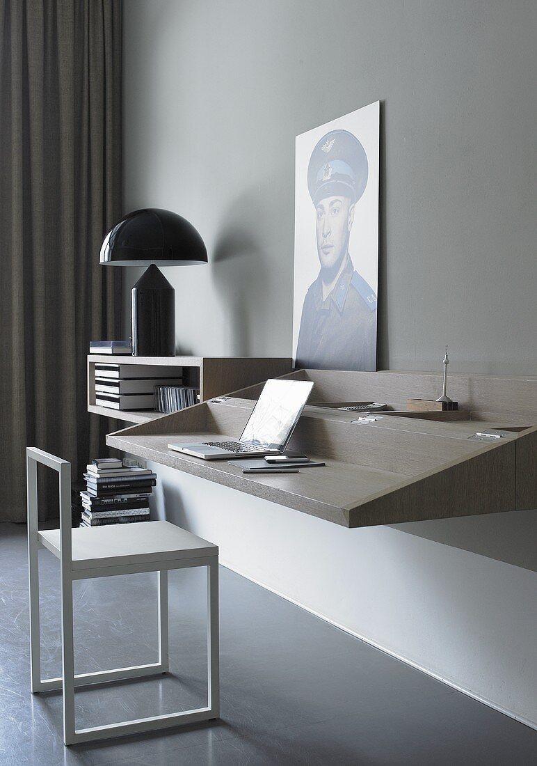 A minimalistic study corner - work on a wall shelf with a designer chair in front of it