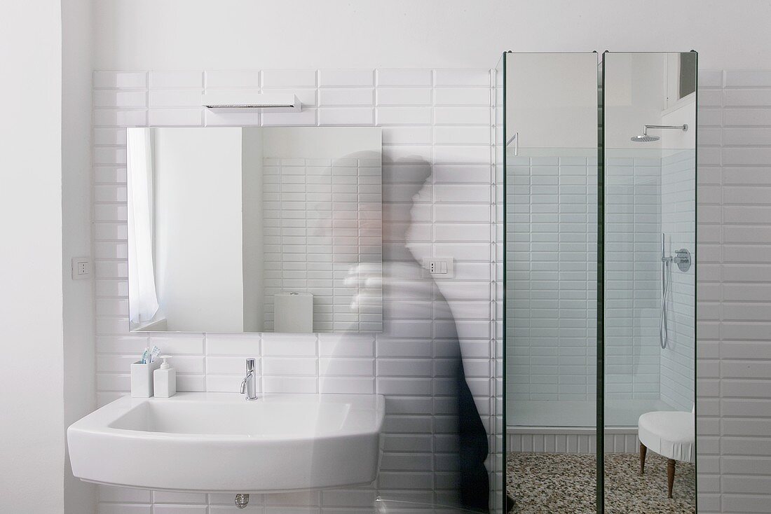 Waschbecken vor weissen Fliesen und Spiegelschrank