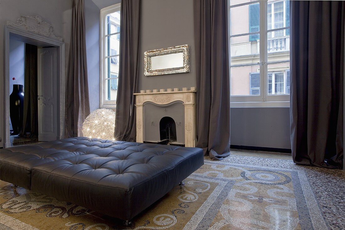 An Art Nouveau-style living room with a terracotta-mosaic floor, a fireplace and a leather sofa