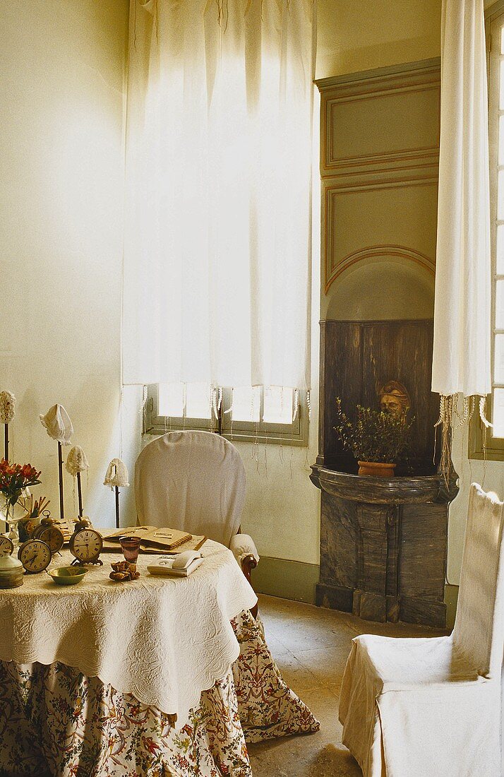 Wohnraumecke mit Steinbecken in Wandnische neben Fenster und Tisch mit Hussenstuhl