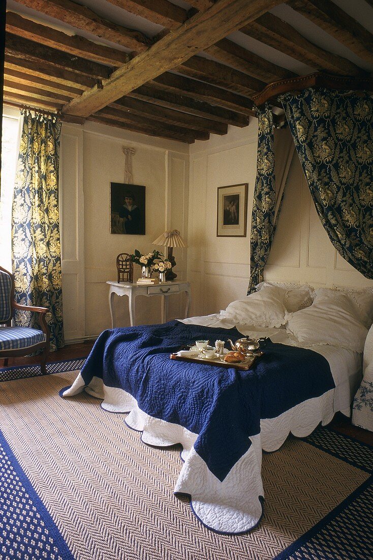 Frühstücken im Bett - abgedunkelter Schlafraum mit Baldachin und rustikaler Holzbalkendecke