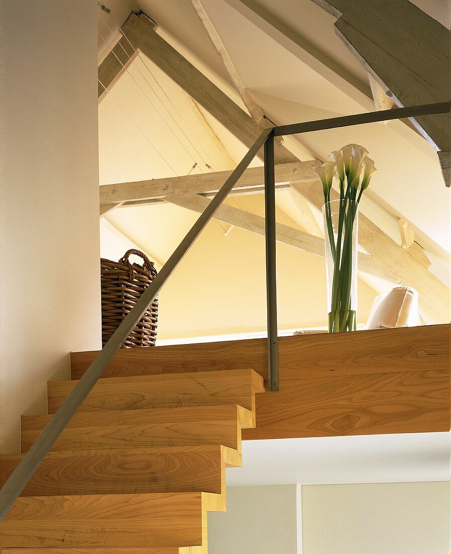 Holztreppe und Galerie mit minimalistischem Geländer im offenen Dachraum