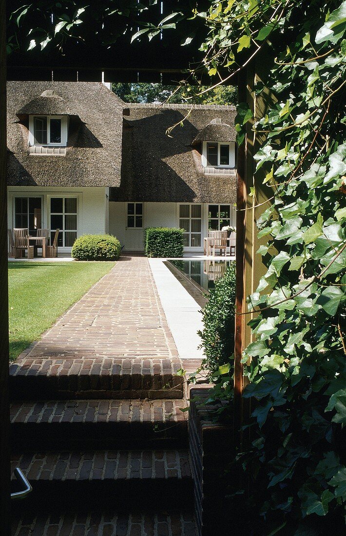A red brick access path to a Flemish-style villa