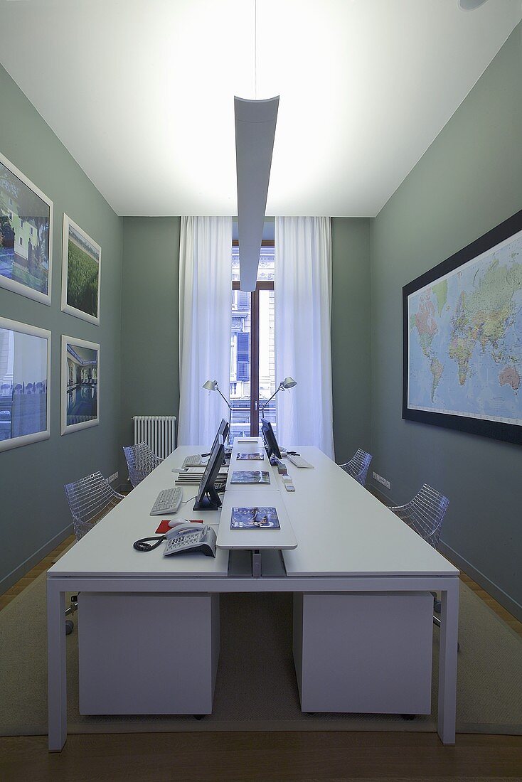 A white desk with indirect lighting in front of a grey wall