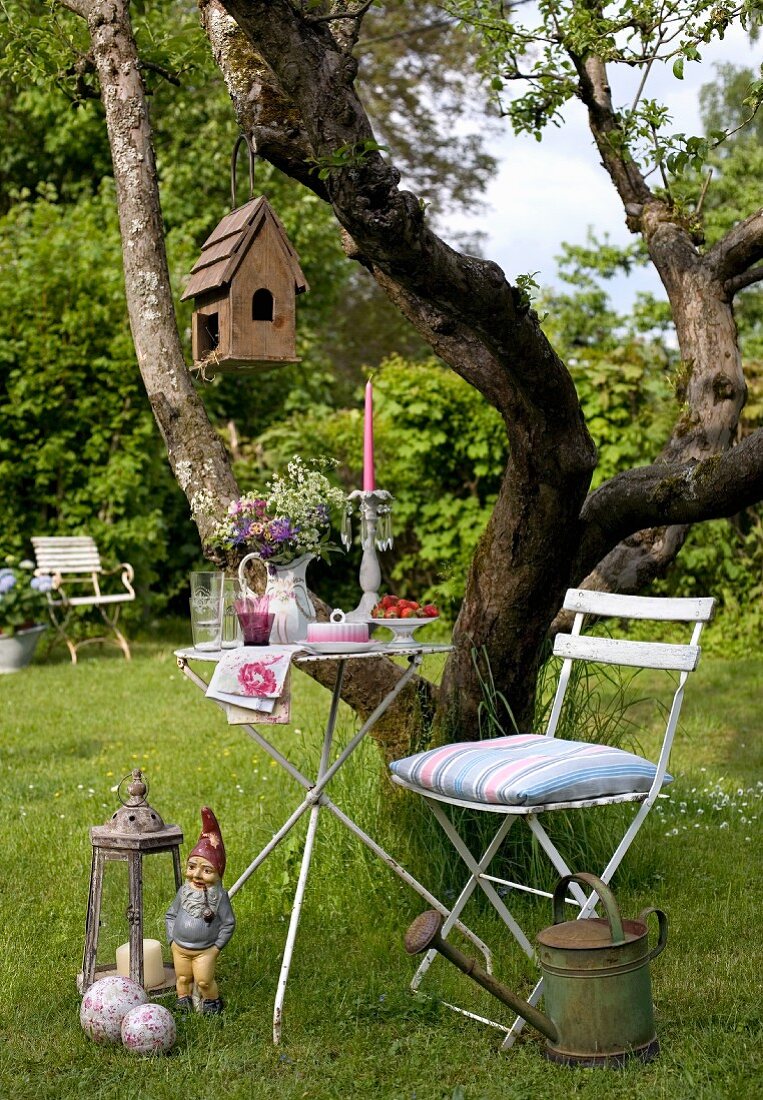Gartentisch mit Stuhl vor dem Baum