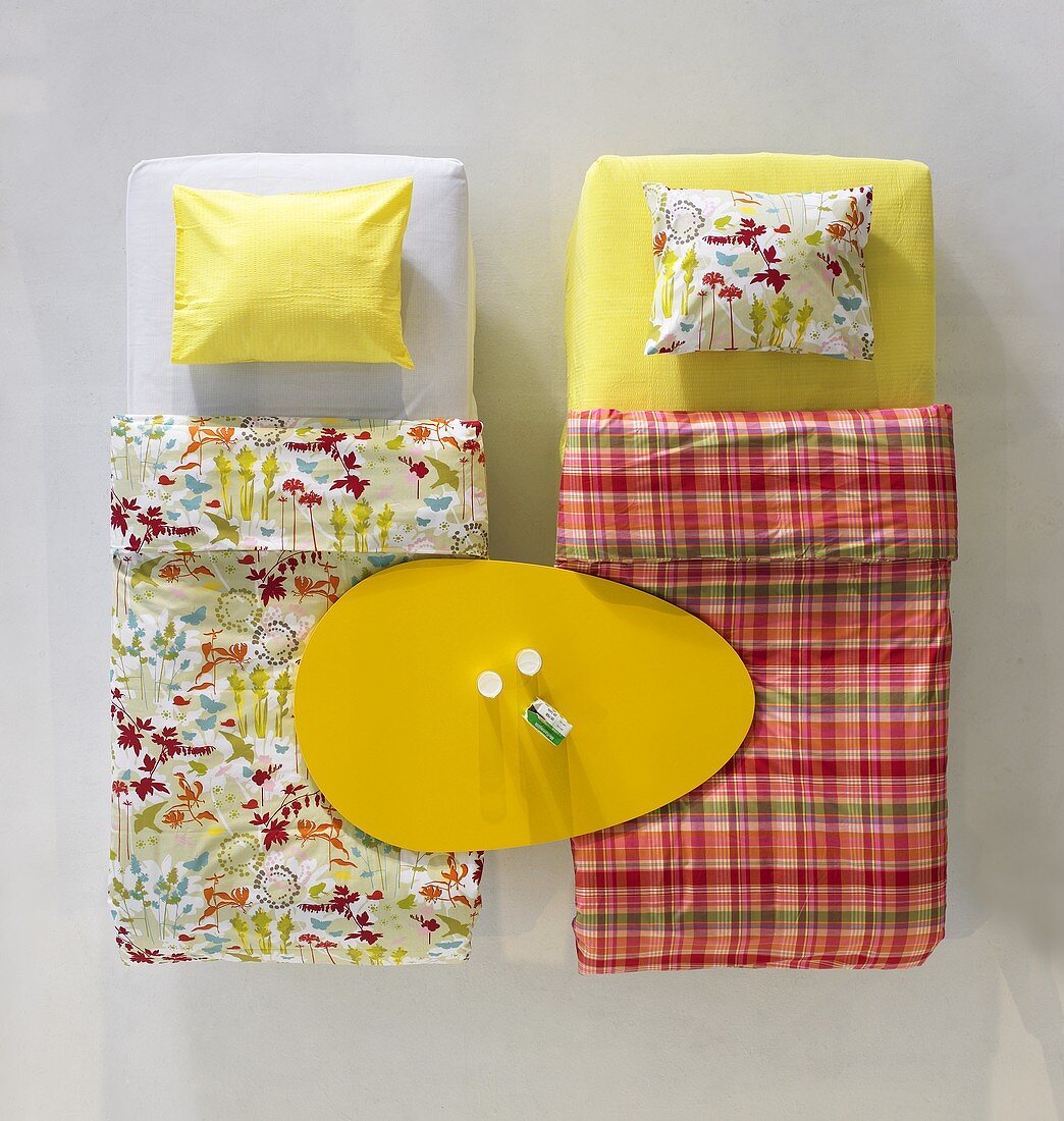 Ostern im Showroom - eiförmige Tischplatte auf zwei Betten mit gemusterter Bettwäsche