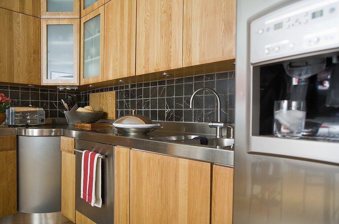 Küchenschränke mit Holzfronten und schwarzen Wandfliesen