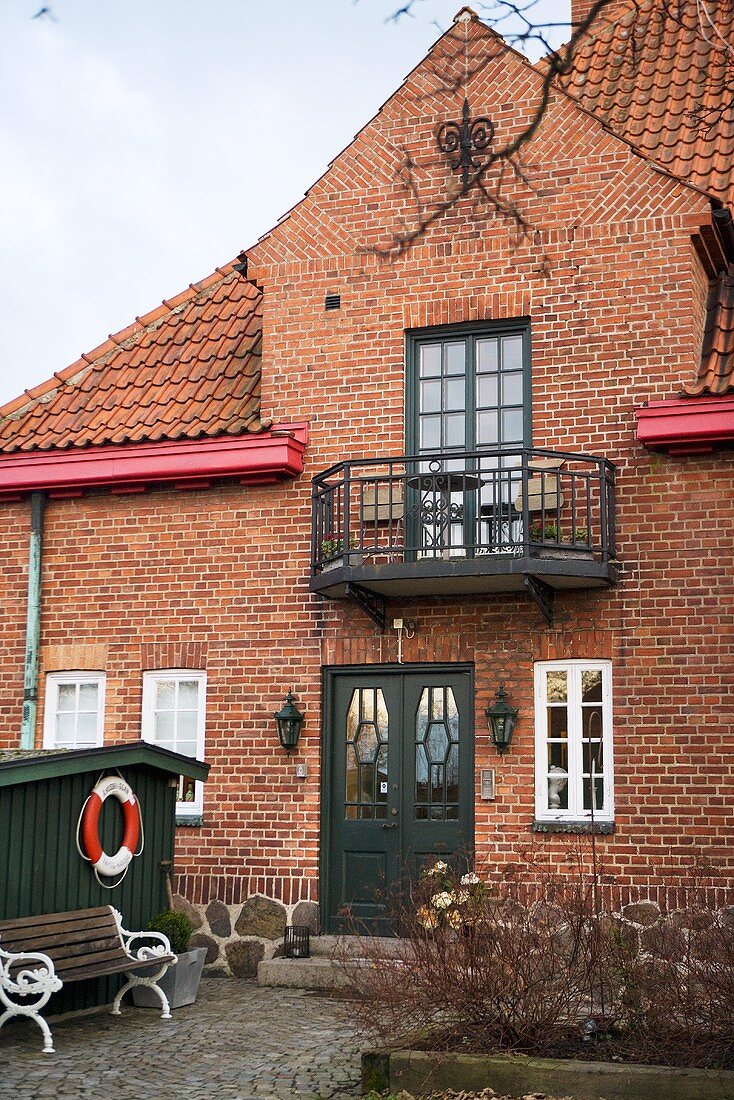 Schwedisches Haus mit Balkon vor Ziegelfassade