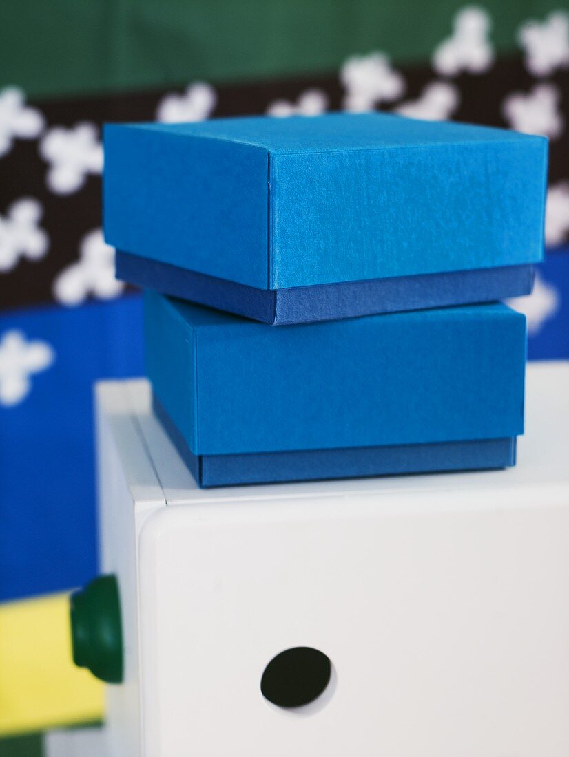 Set of blue paper boxes on a white cabinet