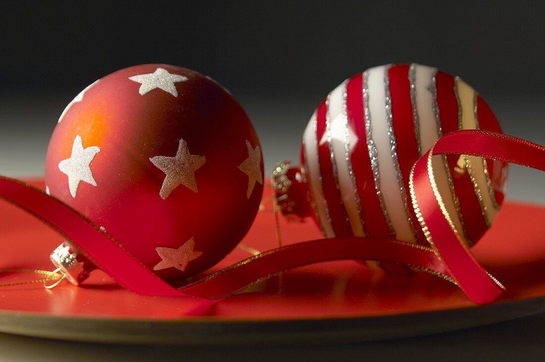 Two red and white striped Christmas baubles