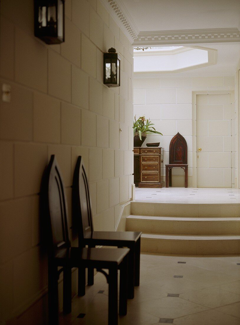 Antike Stühle im Gang und Treppe zum eleganten Vorraum mit Oberlicht