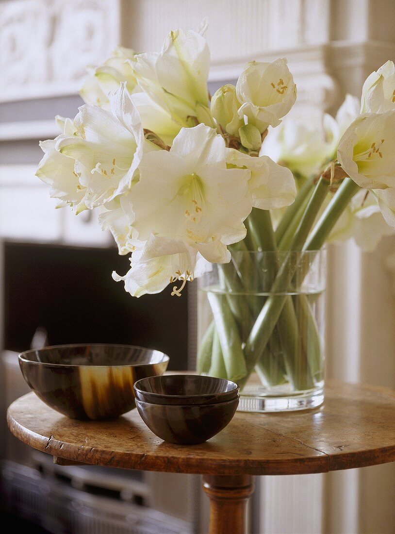 weiße Amaryllis und Schalenset auf Beistelltisch aus Holz