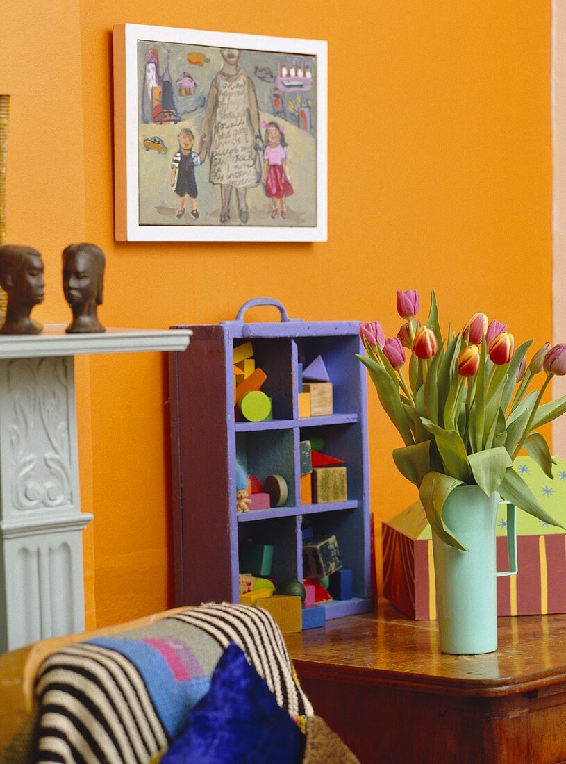 Tulpen in Vase auf Holztisch vor gelber Wand