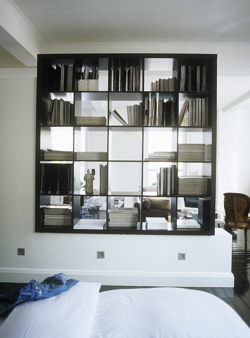 A bookshelf partition dividing a bedroom