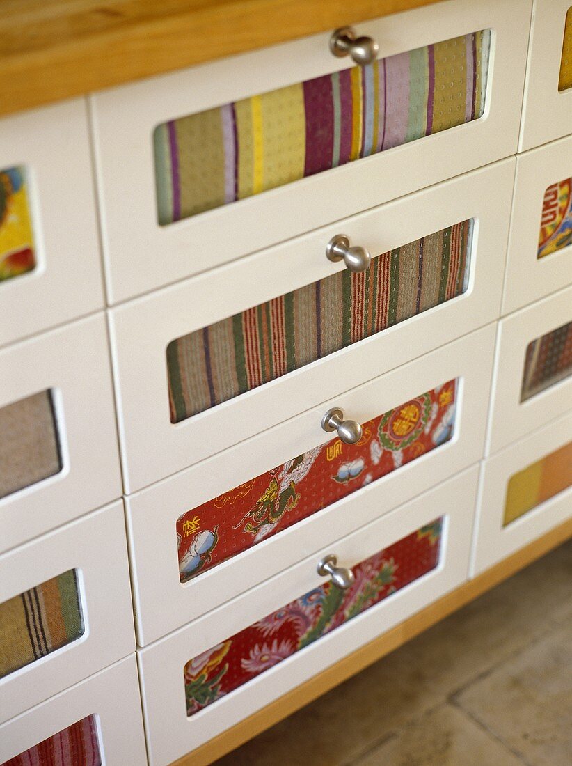Storage drawers with steel handles and fabric set in drawer fronts