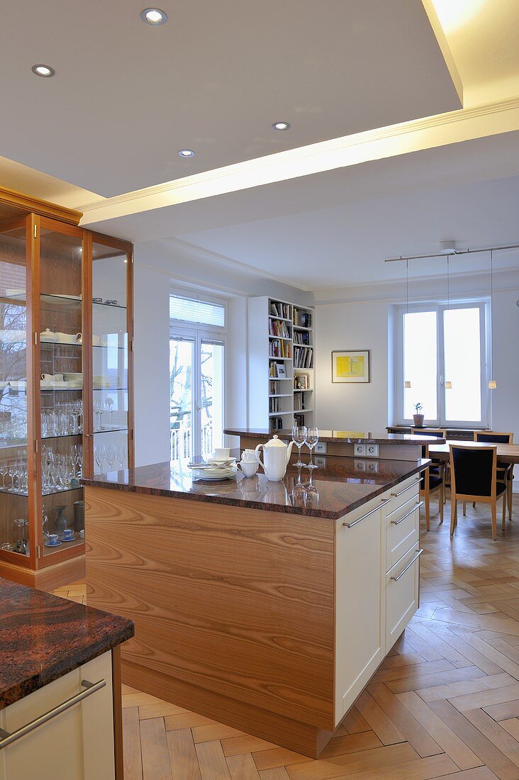 Double central island units in contemporary kitchen in front of display cabinet
