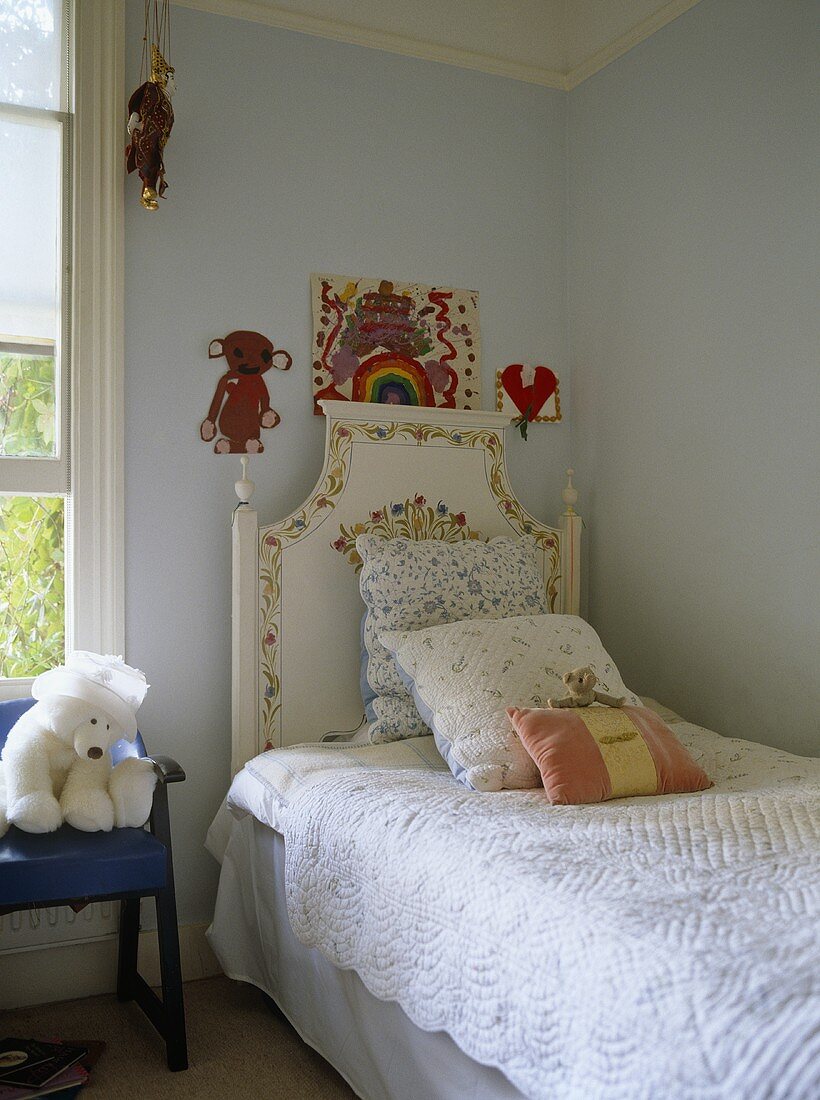 Cushions on single bed in blue bedroom