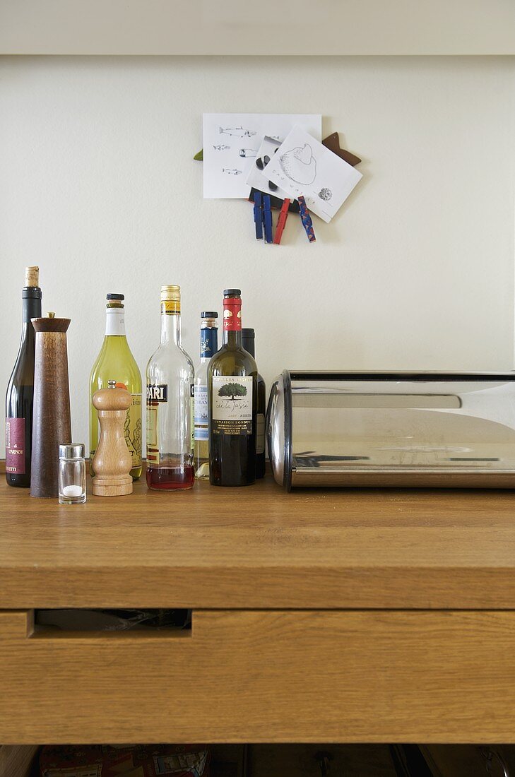 Bottles and bread bin on wooden worktop