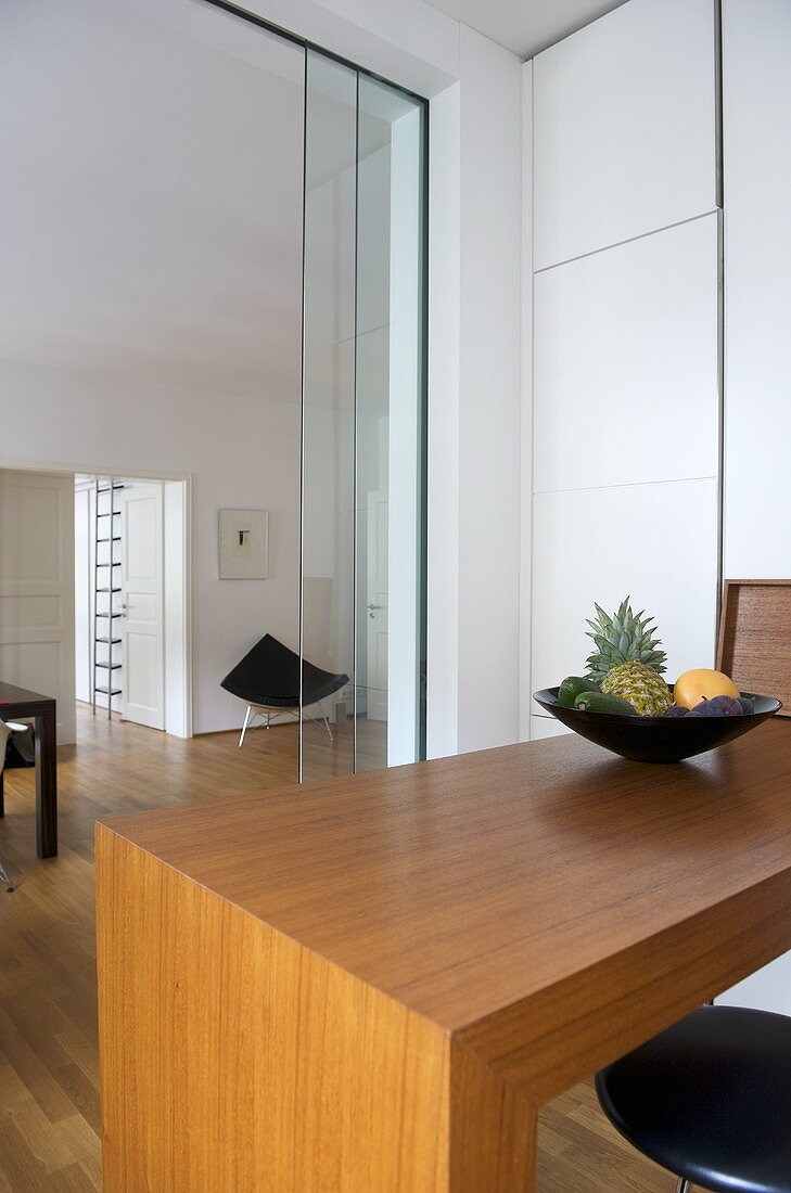 Theke aus Holz vor offener Glastür mit Blick in Wohnraum