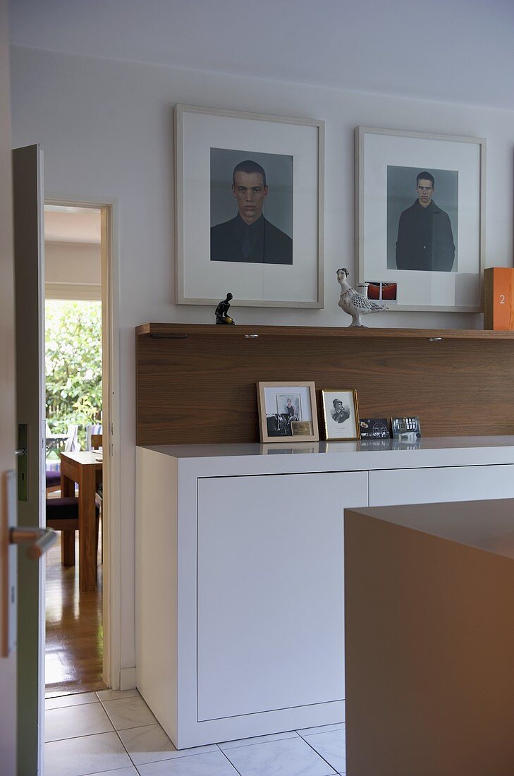 Weisses Sideboard mit Holzablage in moderner Küche