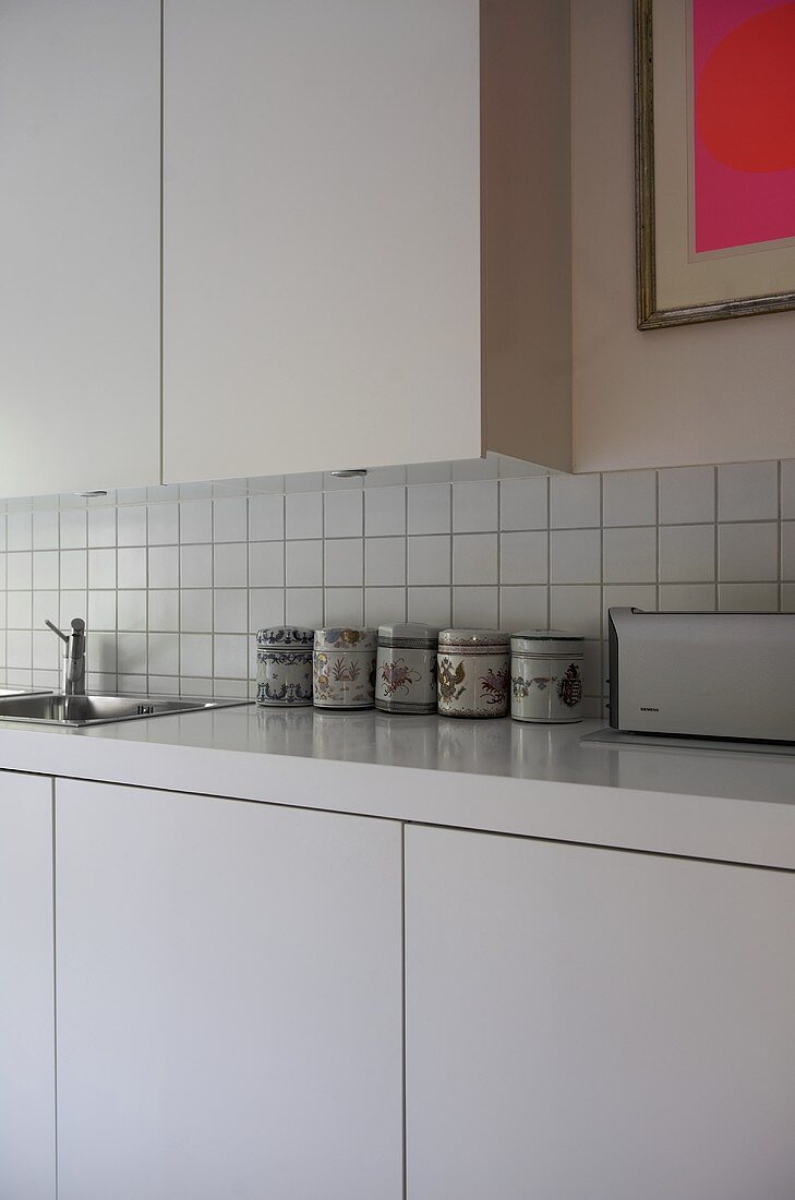 Moderne Küche mit weißen Schrankfronten und Vorratsdosen