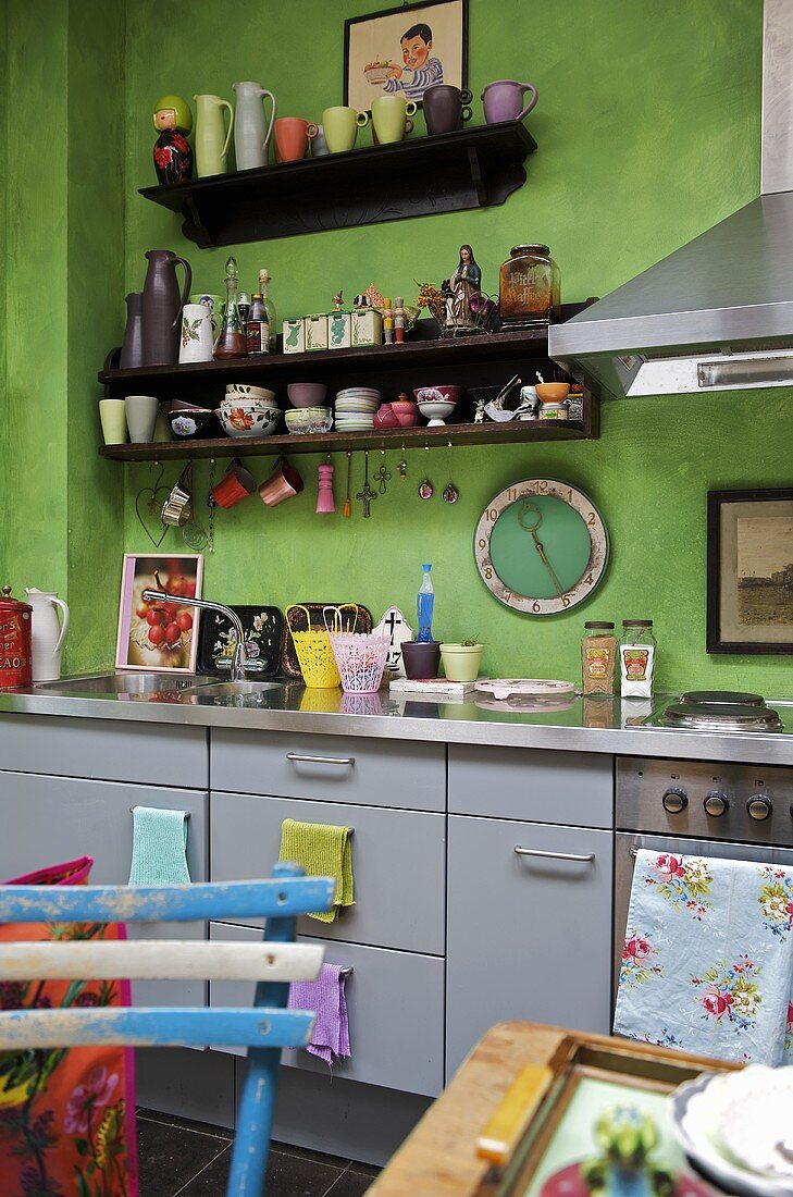 Moderne Küche mit grüner Wand und graue Schrankfronten
