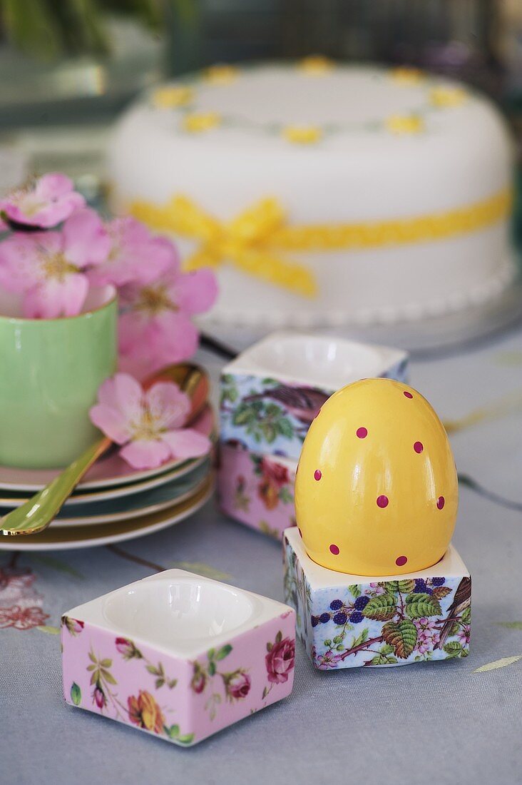 Bemaltes Ei im Eierbecher und dekorierte Torte