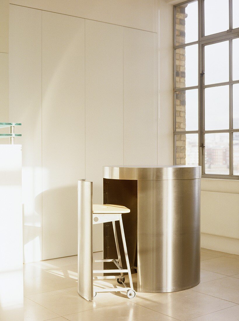 A neat stainless steel table unit comprising built in seat on wheels