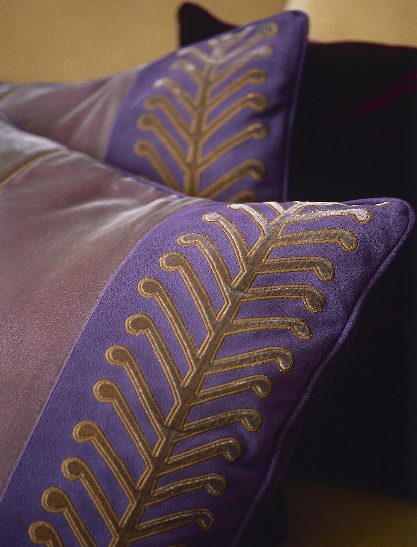 A detail of cushion with purple and gold design,