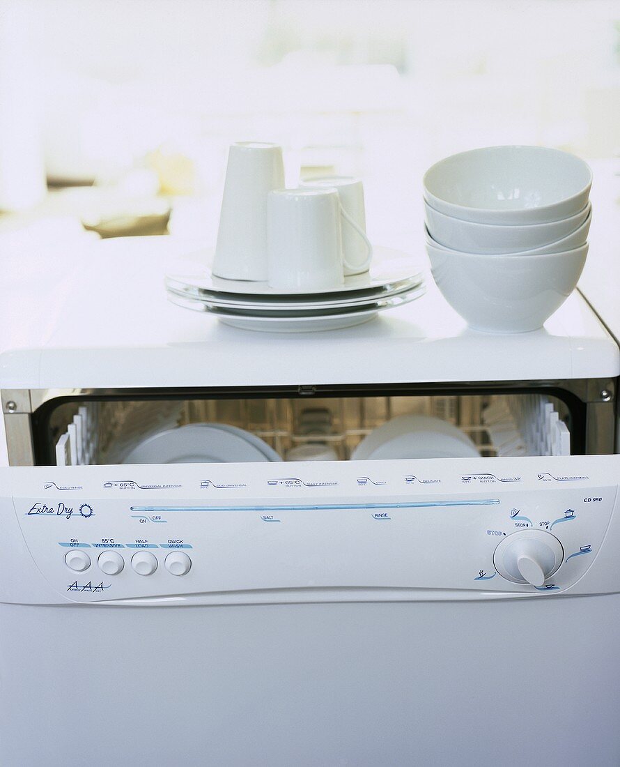 White crockery stacked on a dishwasher